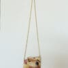 Beaded purse with gold chain and face design.