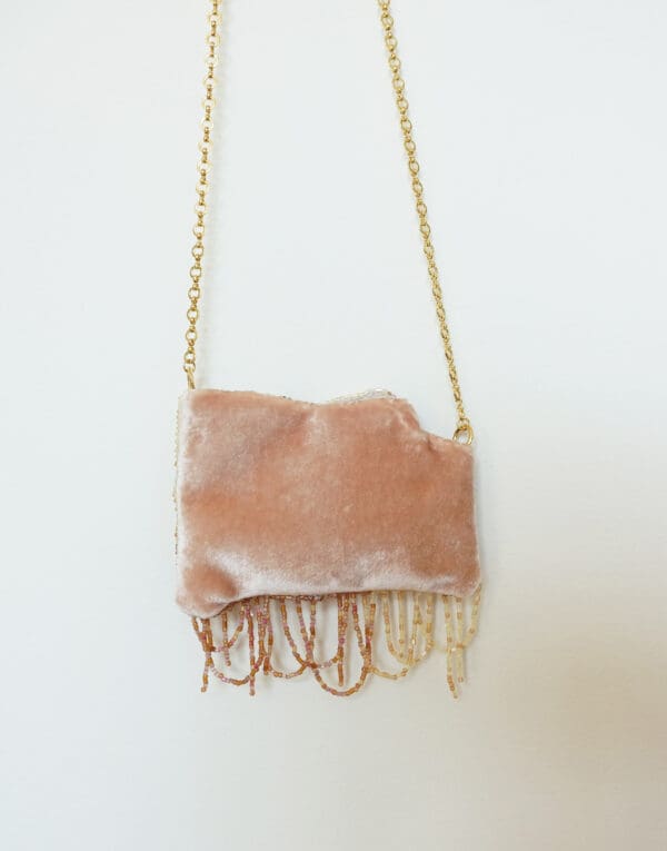 Pink velvet bag with beaded fringe and chain strap.